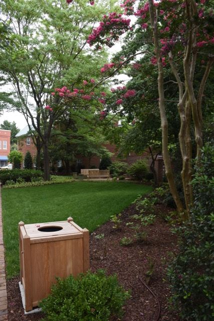 Wood Trash Can at the Edge of a Garden Area